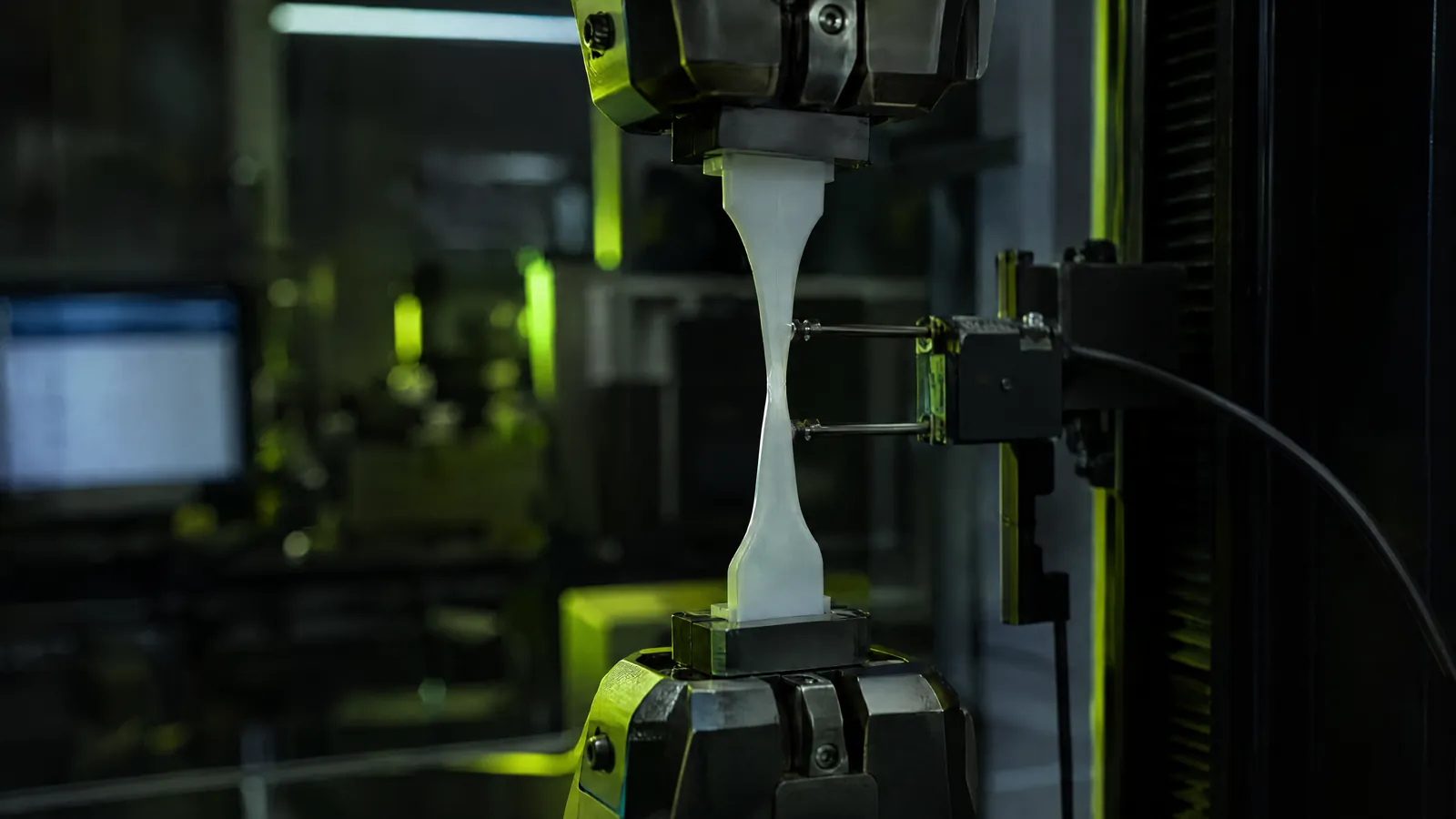 Kunststoffprobe in Schulterstabform in der Zugprüfmaschine